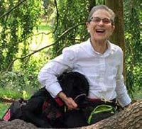 photo of Abby and her service dog Nathan in a wooded setting