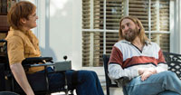 photo of a man in a powered wheelchair talking to another man in a chair