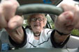 an older driver viewed through the steering wheel