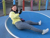 Arkira tries to master the spinning disc at the Magical Bridge Playground
