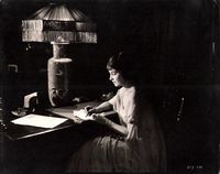 Alice Joyce at writing table with lamp with fringed shade