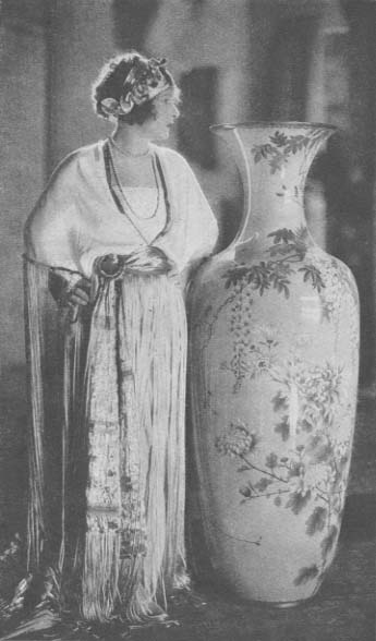 Norma Talmadge standing next to a vase