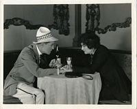 Film still from Madame X, Frederick and man at seedy restaurant