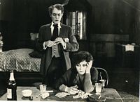 Film still from Madame X, Frederick and man at desk in seedy apartmen