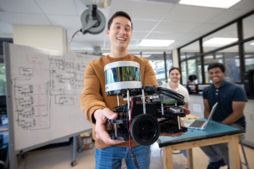 Three students work together in a robotics lab